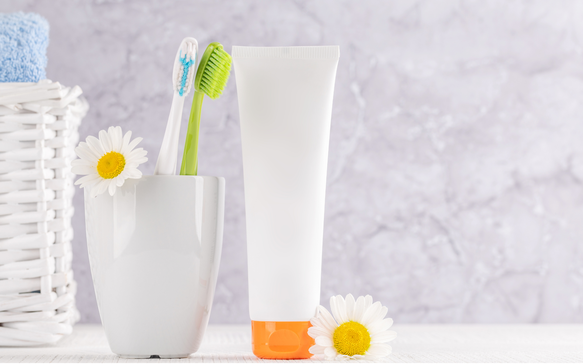 In einem Badezimmer stehen eine Creme und ein Zahnputzbecher